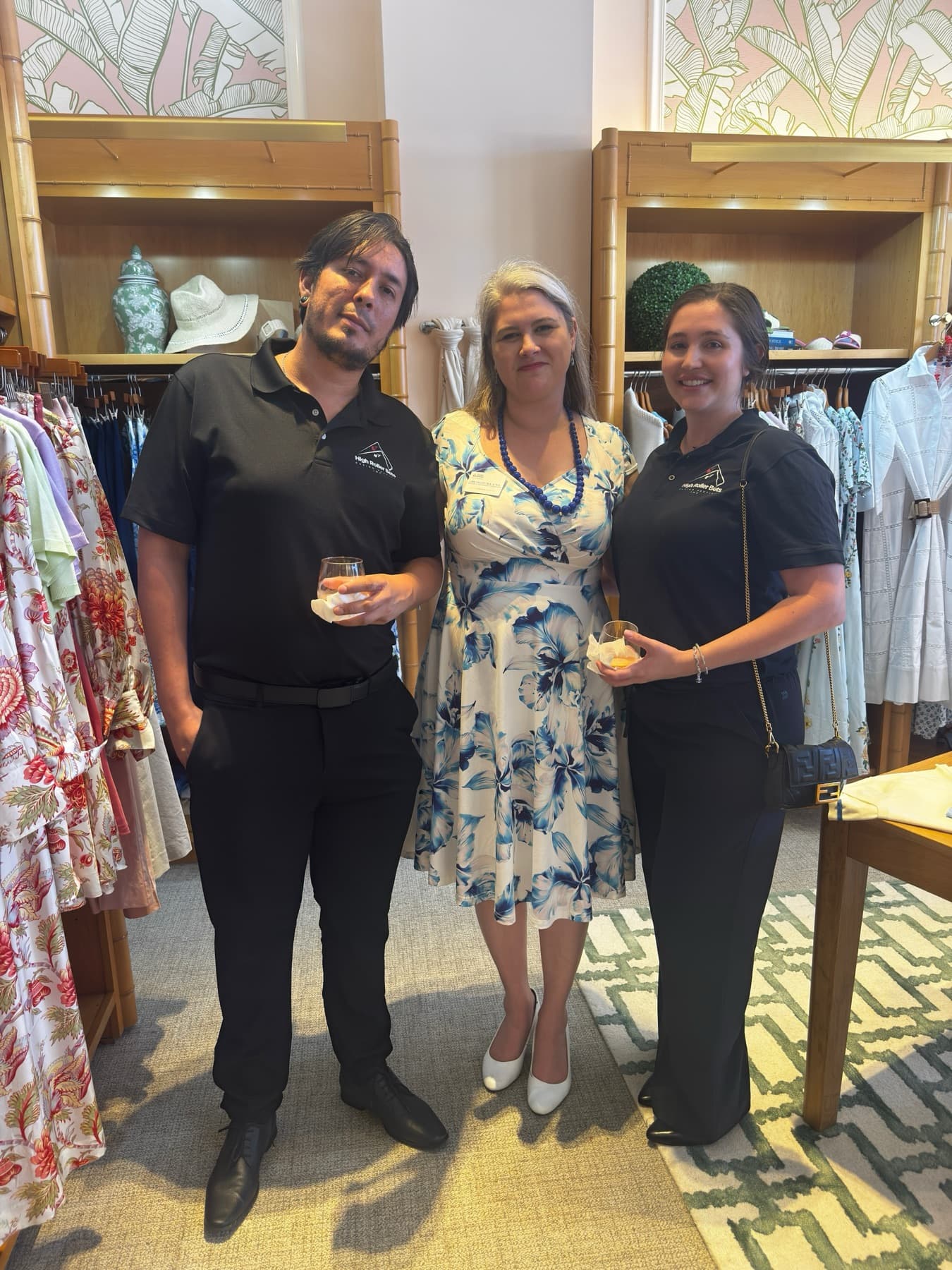 Two High Roller Bets dealers with their host at a boutique event