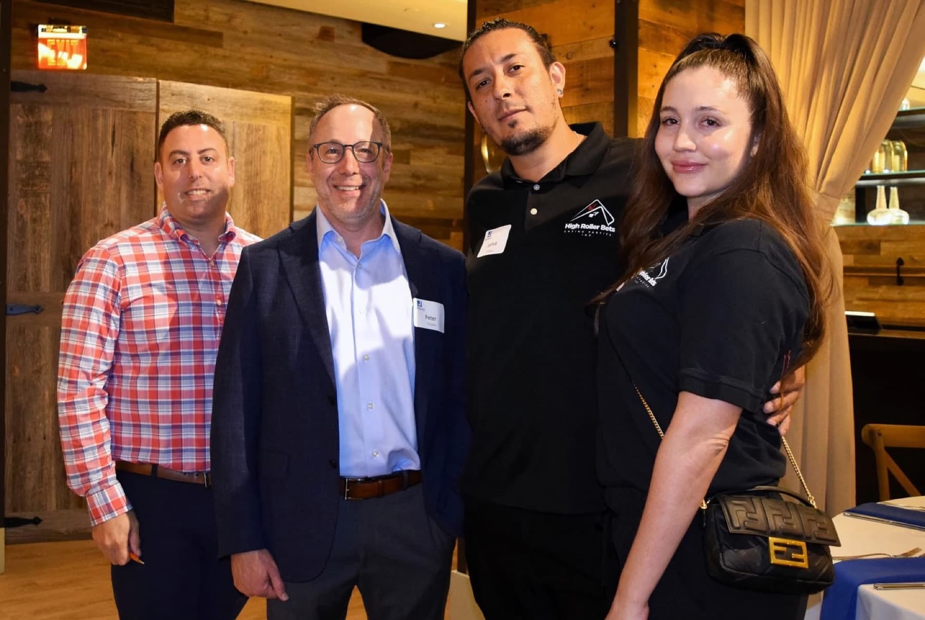 Joshua and a High Roller Bets dealer in black polos with two guests at a corporate event
